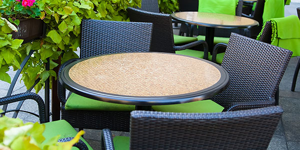 Wicker patio tables and chairs with green cushions